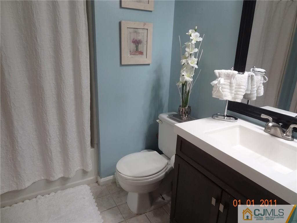 1019 Edpas Road, Unit 1019 New Brunswick, NJ 08901 - Photo 7 of 18 a bathroom with a sink a toilet and mirror