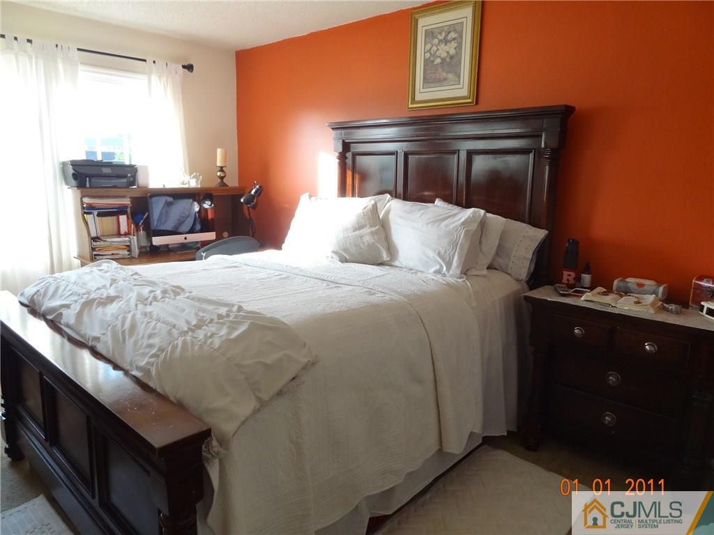 1019 Edpas Road, Unit 1019 New Brunswick, NJ 08901 - Photo 8 of 18 a bed sitting in a bedroom next to a window with pc on it