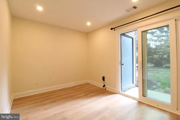 a view of a big room with wooden floor and windows