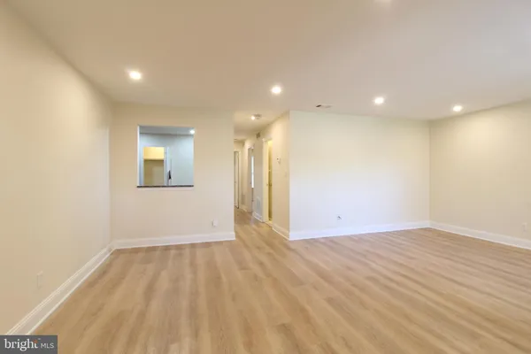 an empty room with wooden floor and a natural light