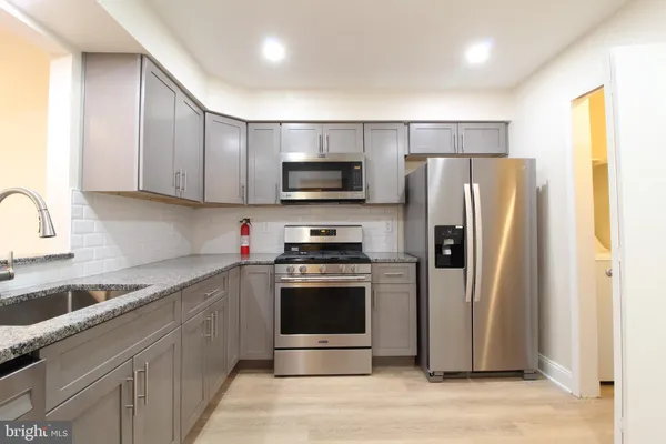 a kitchen with stainless steel appliances a refrigerator stove and sink