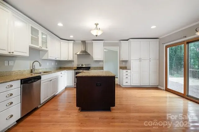 a large kitchen with cabinets and wooden floor