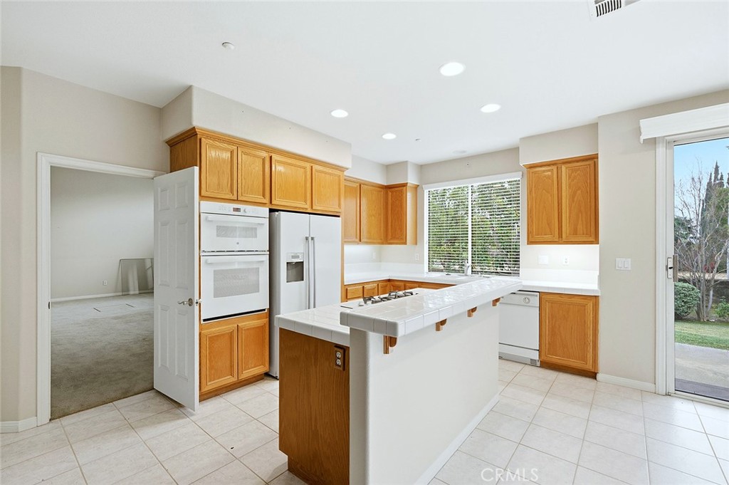 9379 Monarch Court Rancho Cucamonga, CA 91737 - Photo 4 of 19 a kitchen with a refrigerator and a stove top oven