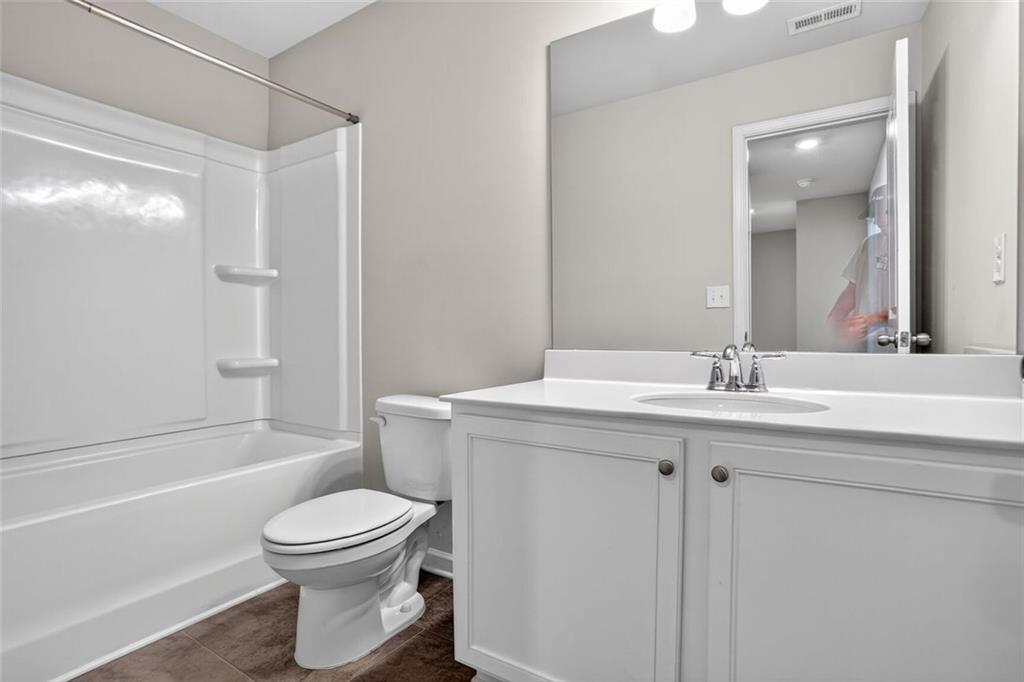 1553 Spring Hollow Way Stone Mountain, GA 30083 - Photo 21 of 25 a bathroom with a sink a toilet and shower