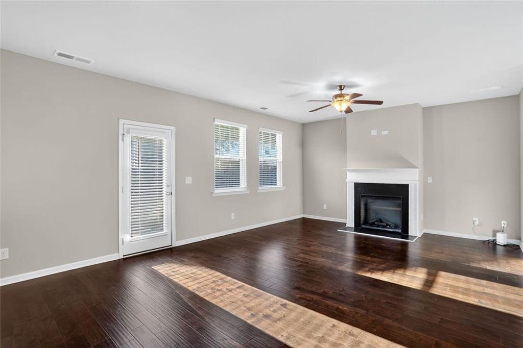1553 Spring Hollow Way Stone Mountain, GA 30083 - Photo 6 of 25 an empty room with windows and a fireplace
