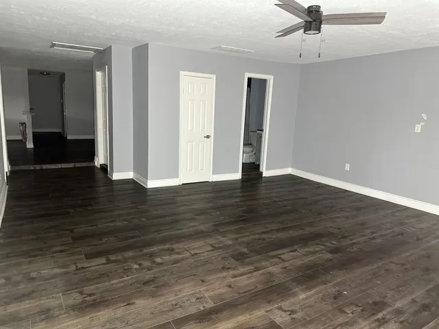 a view of an empty room with wooden floor