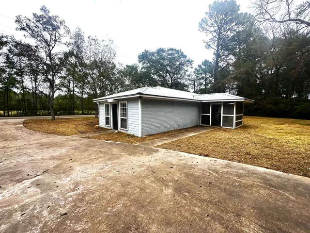 a view of a house with backyard and trees