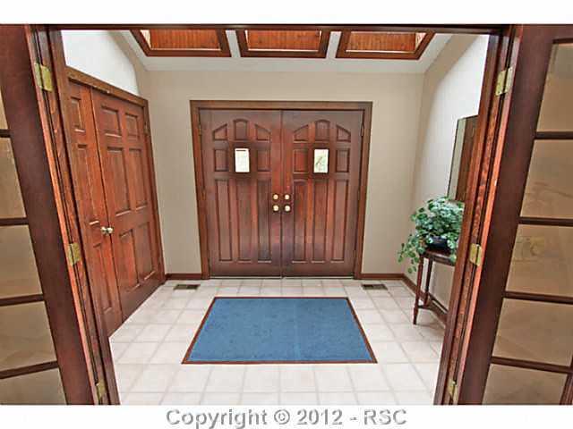 13010 Bridle Bit Road Colorado Springs, CO 80908 - Photo 24 of 25 Stunning entryway with skylights, tiled flooring with carpet inlay, ample closet space to accommodate guests outerwear. This home is bright throughout.