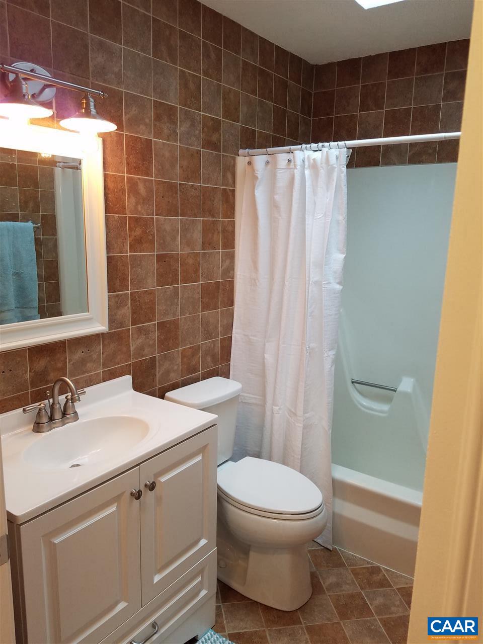 19 Holmes Run Road Stanardsville, VA 22973 - Photo 8 of 19 a bathroom with a sink a toilet and shower