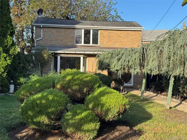 a view of a house with a backyard and sitting area
