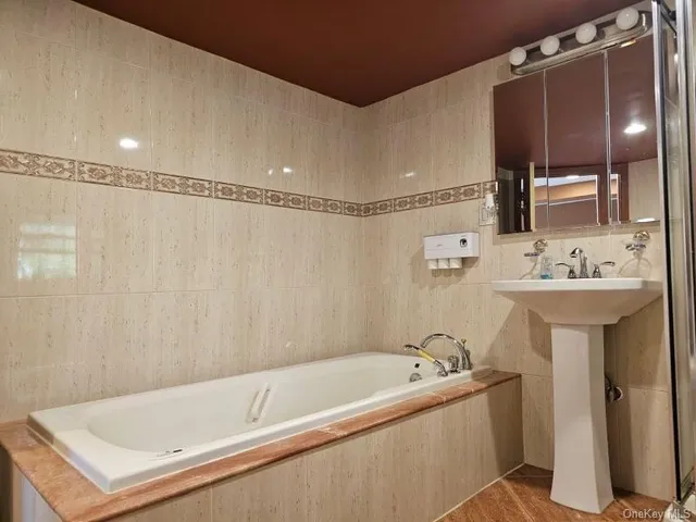 a bathroom with a sink a mirror and a bathtub