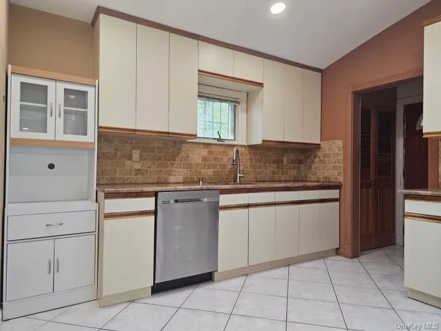 a kitchen with granite countertop white cabinets