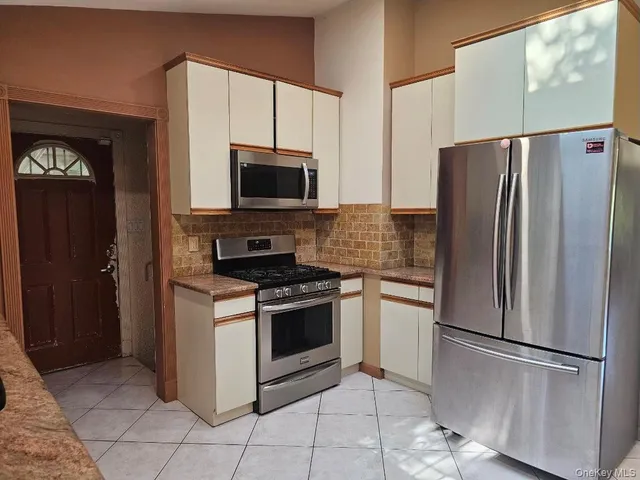 a kitchen with stainless steel appliances granite countertop a refrigerator stove and microwave