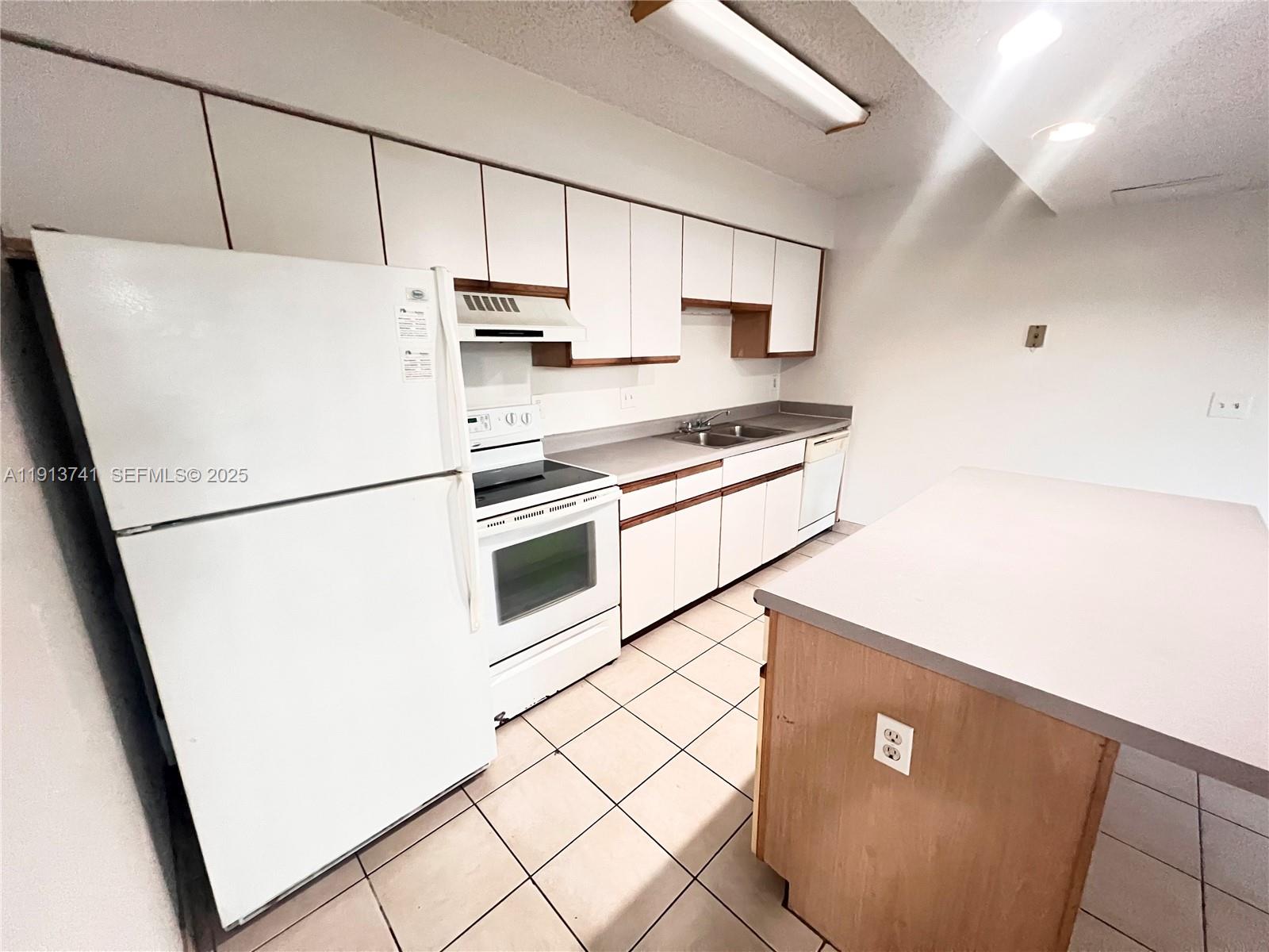 a kitchen with stainless steel appliances a refrigerator sink and microwave