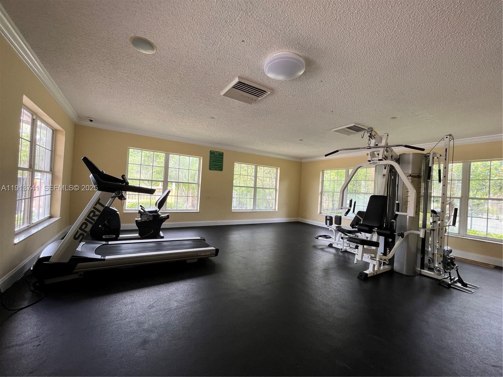 4055 West McNab Road, Unit H104 Pompano Beach, FL 33069 - Photo 12 of 14 a view of a room with gym equipment and windows