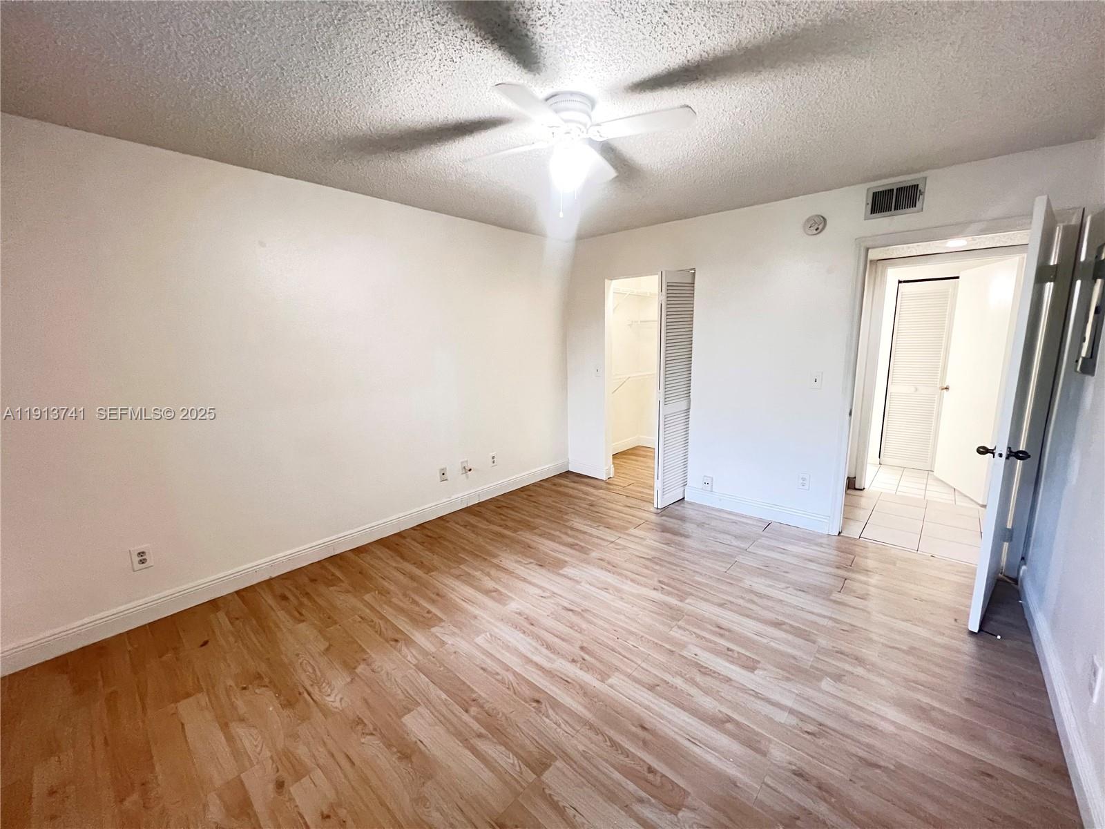 4055 West McNab Road, Unit H104 Pompano Beach, FL 33069 - Photo 5 of 14 wooden floor in an empty room with a window
