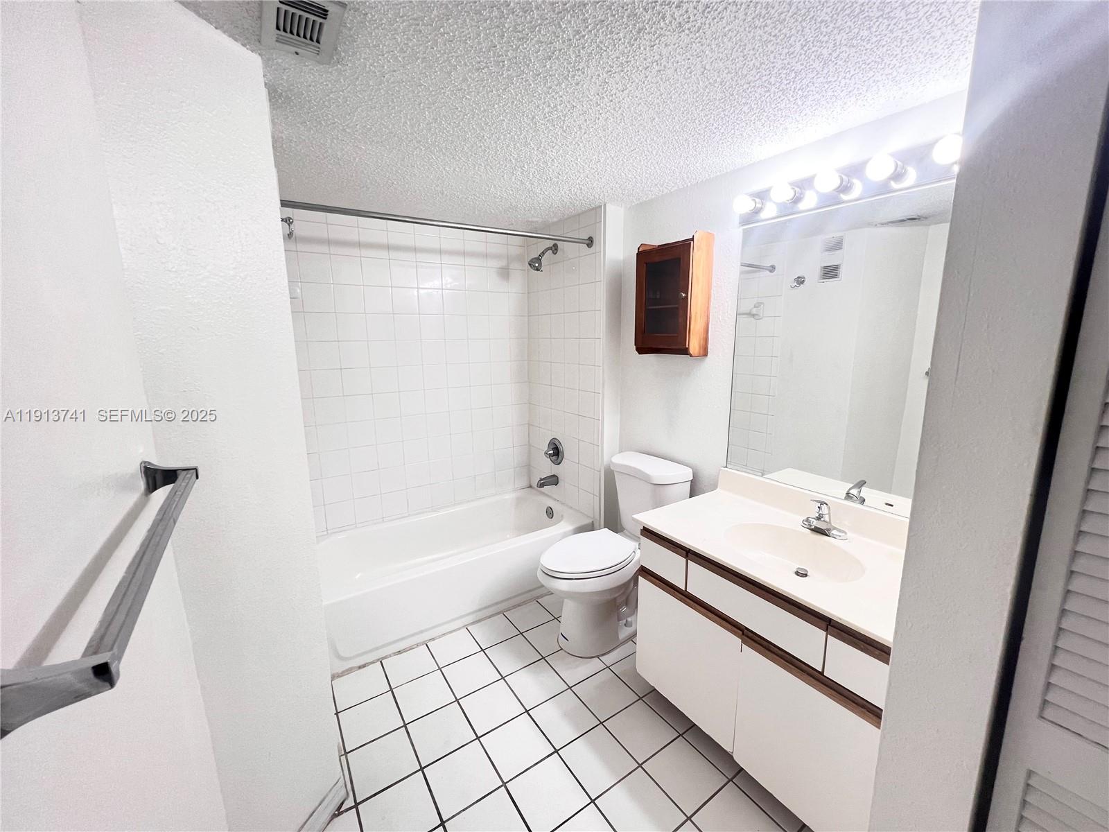 4055 West McNab Road, Unit H104 Pompano Beach, FL 33069 - Photo 7 of 14 a bathroom with a sink a toilet a mirror and shower