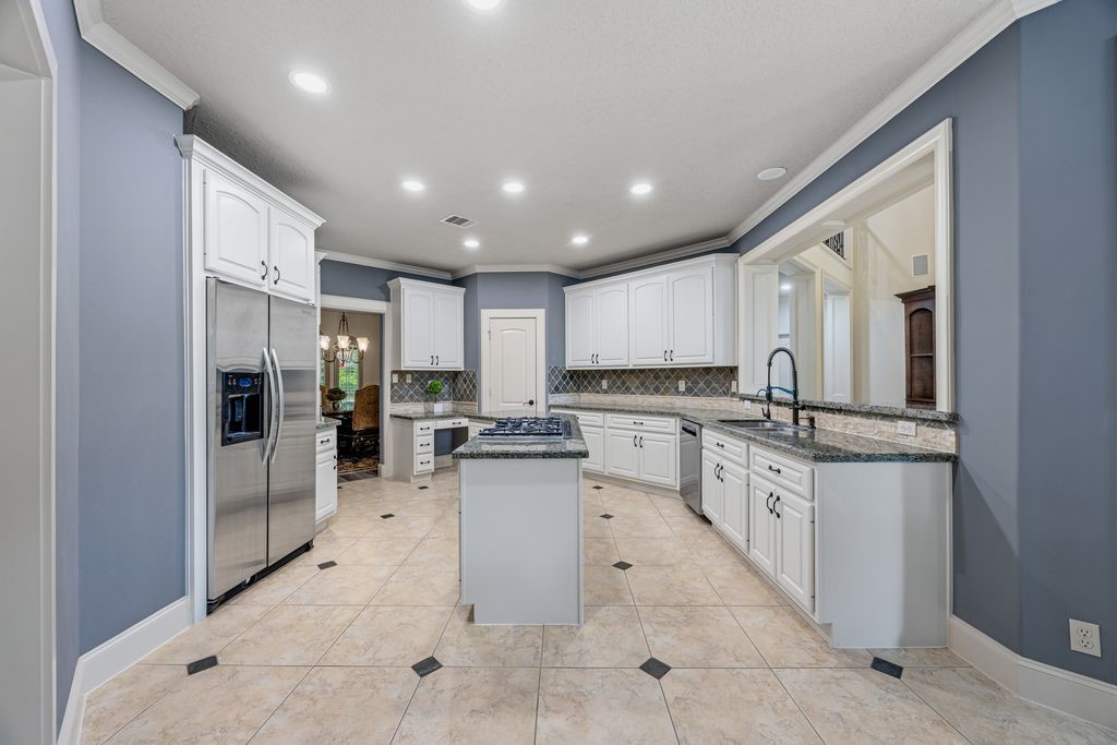 27722 Tiverton Court Spring, TX 77386 - Photo 9 of 33 Designed for the Passionate Cook!
Generous prep areas, abundant storage, and a striking center island with chef-style cooktop make this kitchen as functional as it is beautiful. Open to both the living room and casual dining area, it keeps everyone connected whether hosting guests or preparing everyday meals.