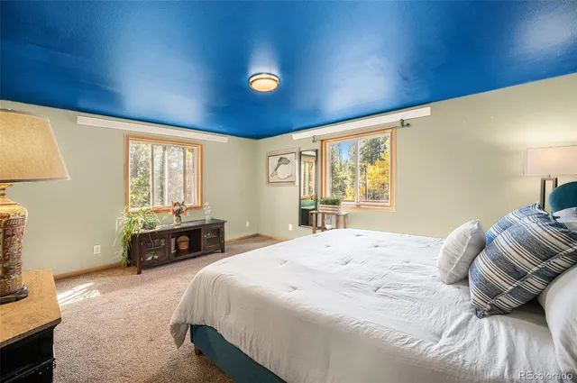 a spacious bedroom with a bed and wooden floor