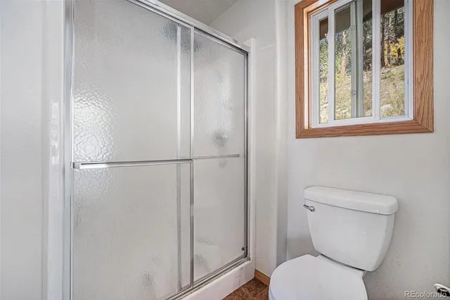 a bathroom with a toilet and a shower