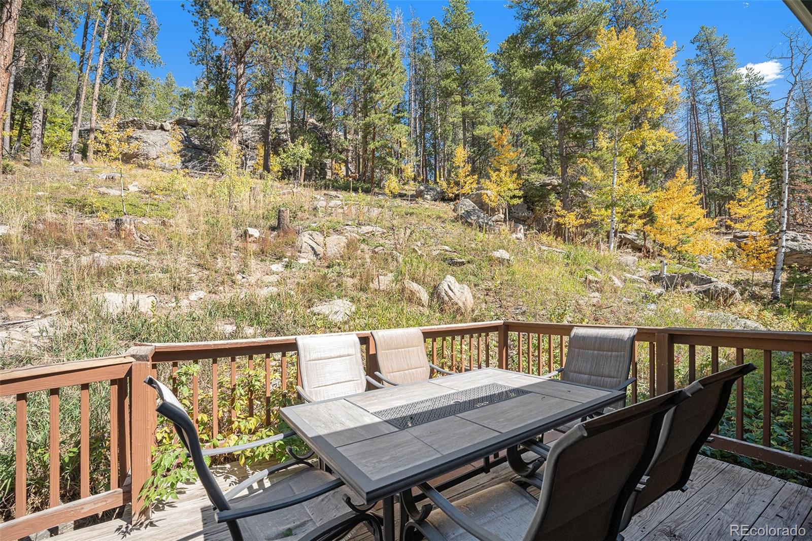 21795 Indian Springs Road Conifer, CO 80433 - Photo 22 of 29 a view of a balcony with wooden floor and outdoor seating
