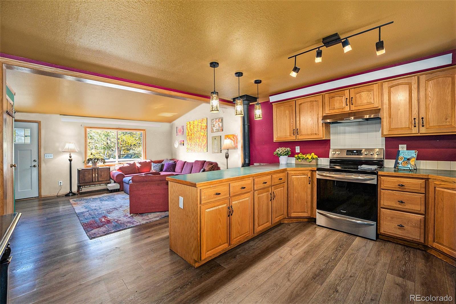 21795 Indian Springs Road Conifer, CO 80433 - Photo 8 of 29 a large kitchen with stainless steel appliances granite countertop a stove and a wooden floors