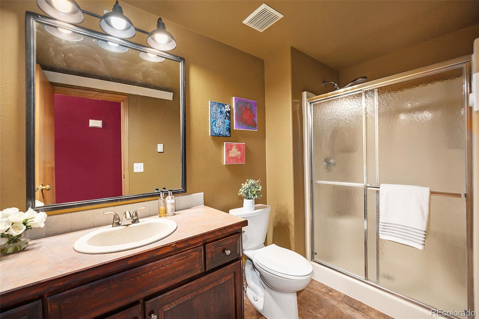 21795 Indian Springs Road Conifer, CO 80433 - Photo 10 of 29 a bathroom with a sink a toilet a mirror and shower