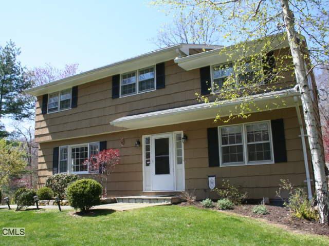 153 Wilton Road East Ridgefield, CT 06877 - Photo 1 of 1 a front view of a house with a yard and garage
