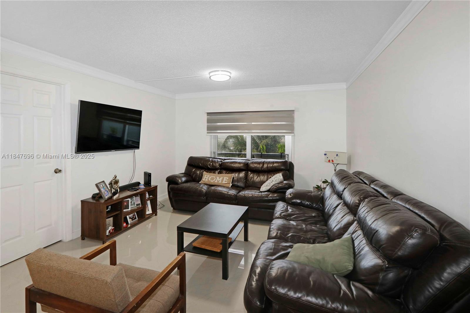 9917 West Okeechobee Road, Unit 3303 Hialeah Gardens, FL 33016 - Photo 11 of 26 a living room with furniture and a flat screen tv