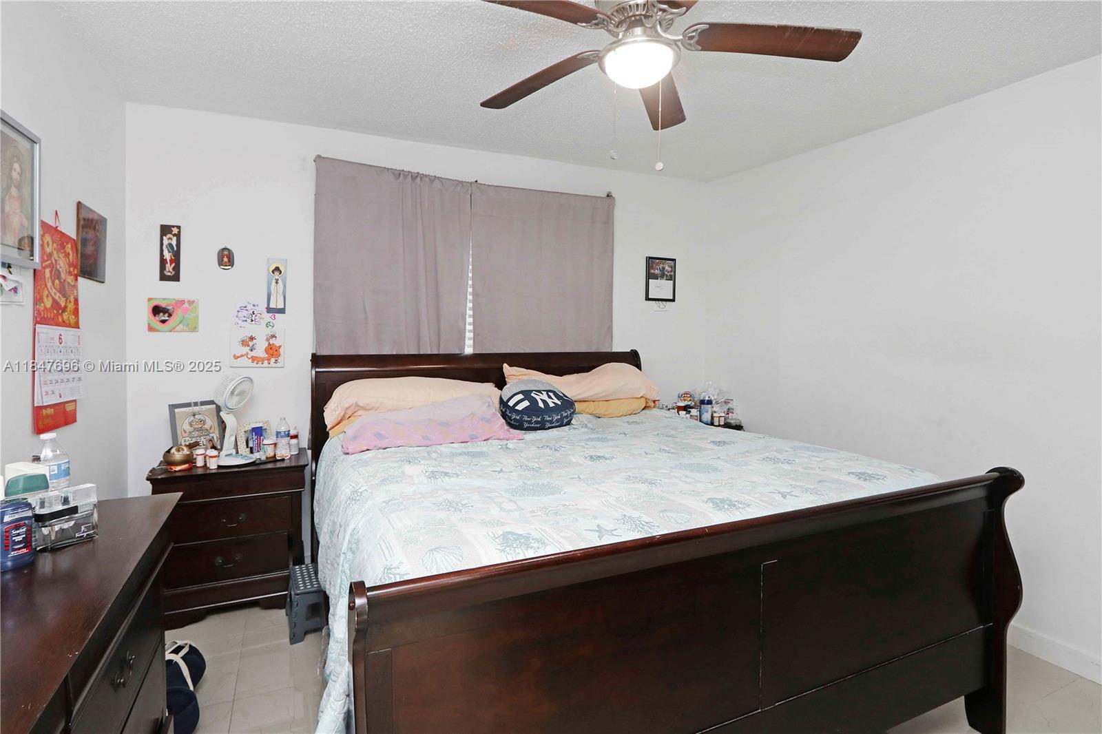 9917 West Okeechobee Road, Unit 3303 Hialeah Gardens, FL 33016 - Photo 18 of 26 a bedroom with a bed and a chandelier