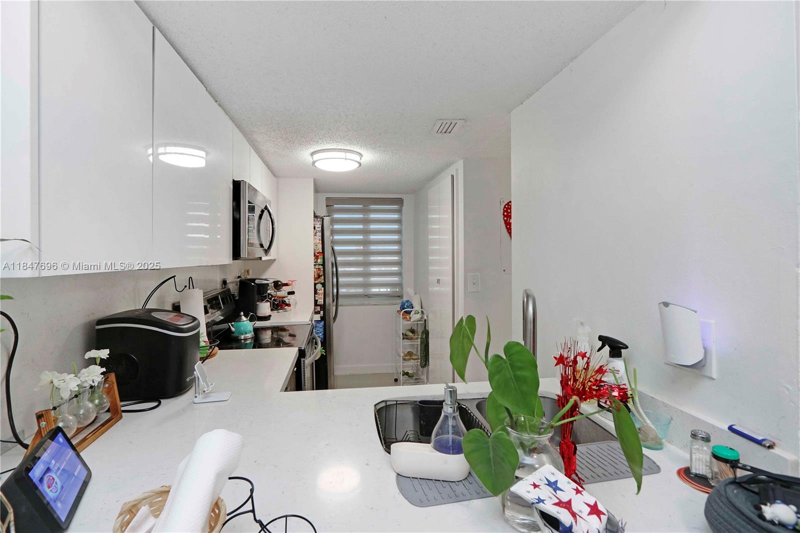 9917 West Okeechobee Road, Unit 3303 Hialeah Gardens, FL 33016 - Photo 6 of 26 a living room with furniture a rug and a potted plant
