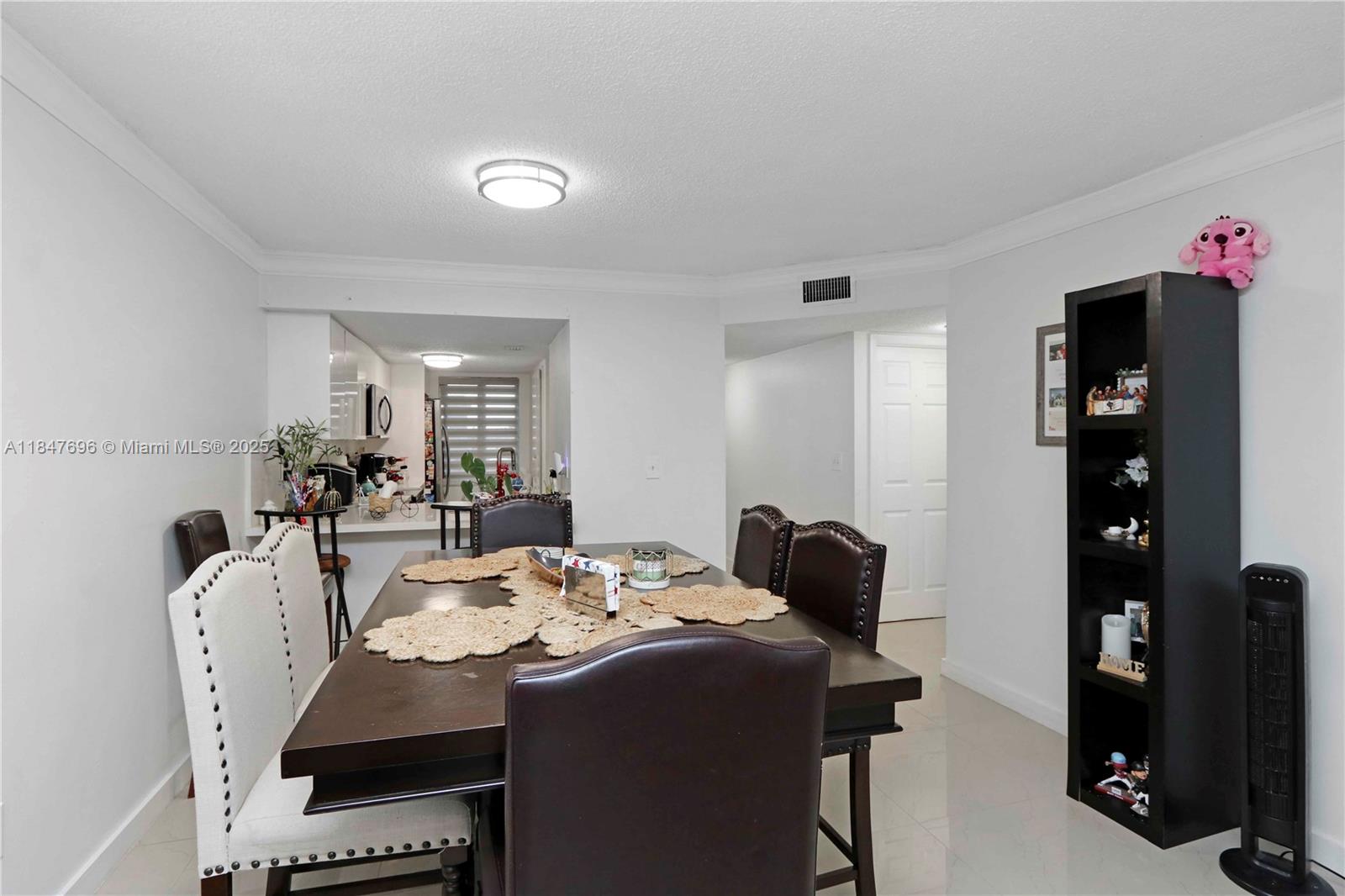 9917 West Okeechobee Road, Unit 3303 Hialeah Gardens, FL 33016 - Photo 9 of 26 a dining room with furniture and wooden floor