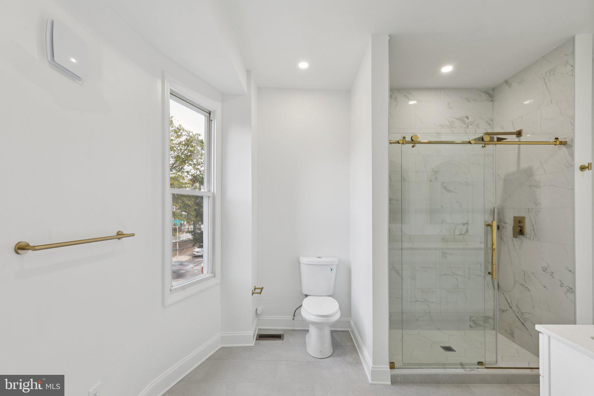 137 Manheim Street Philadelphia, PA 19144 - Photo 35 of 81 a bathroom with a shower a toilet and a window