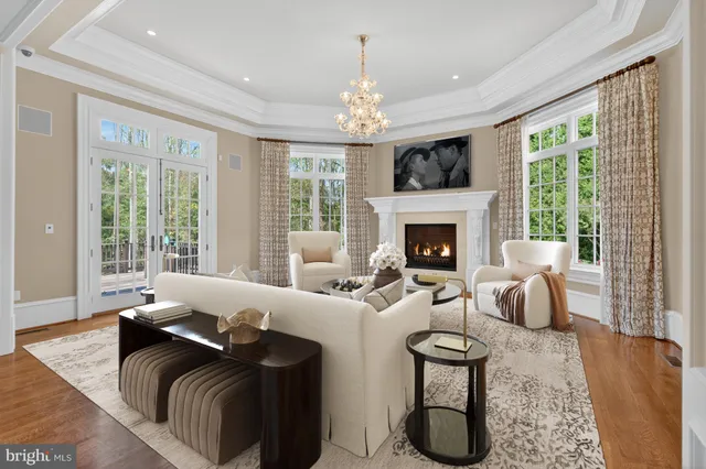 a living room with furniture fireplace and large windows