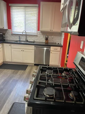 a kitchen with kitchen island granite countertop a stove and a sink