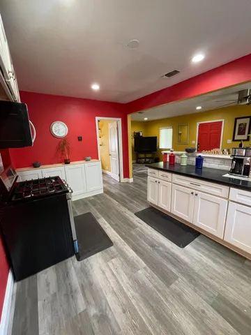 a kitchen with stainless steel appliances kitchen island granite countertop a stove a sink and a microwave