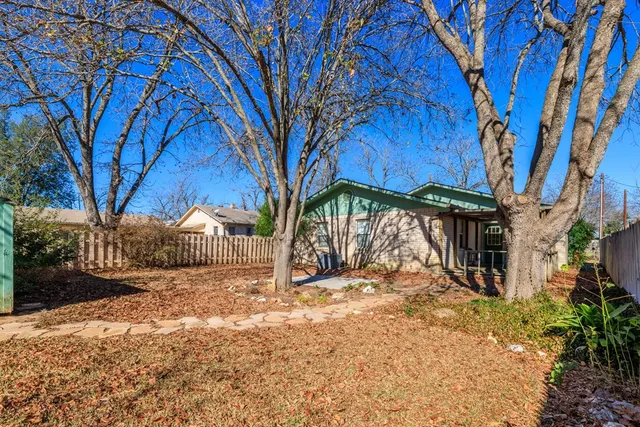 a view of a yard with wooden fence and a large tree