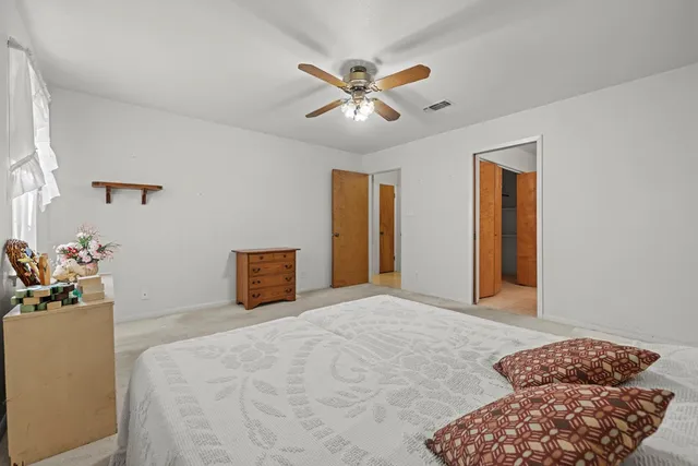 a bedroom with a bed and ceiling fan