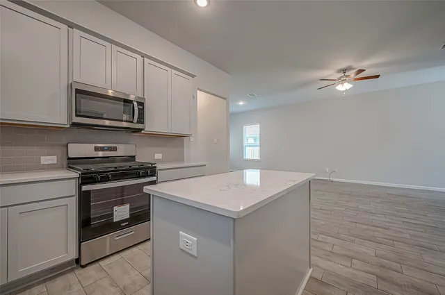 a kitchen with a sink stove and microwave