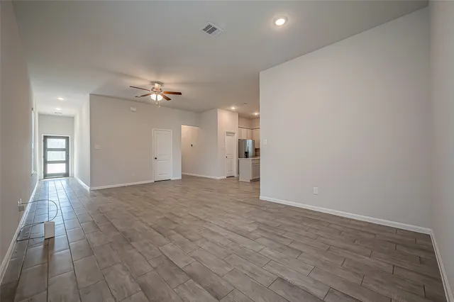 a view of an empty room with wooden floor