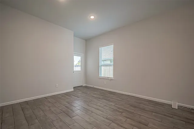 wooden floor in an empty room with a window