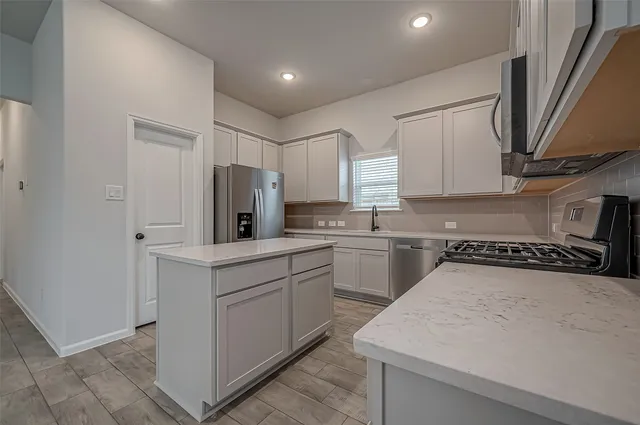 a kitchen with a refrigerator a sink and cabinets