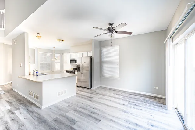 a view of kitchen with stainless steel appliances granite countertop a stove oven and a refrigerator with wooden floor