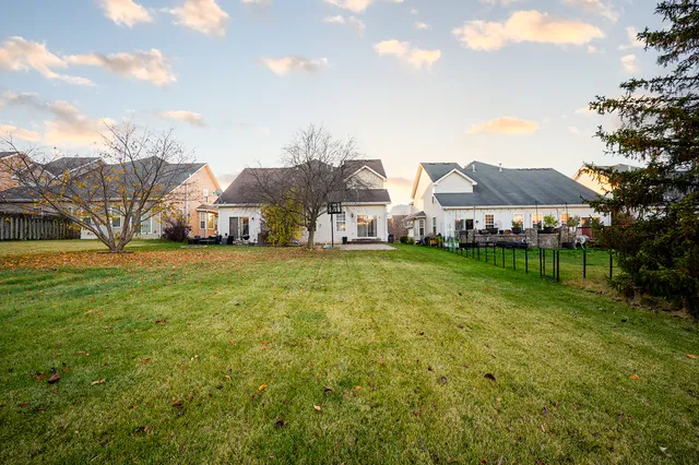a view of a house with a big yard and large trees