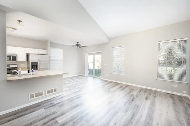 a view of a kitchen with wooden floor and windows