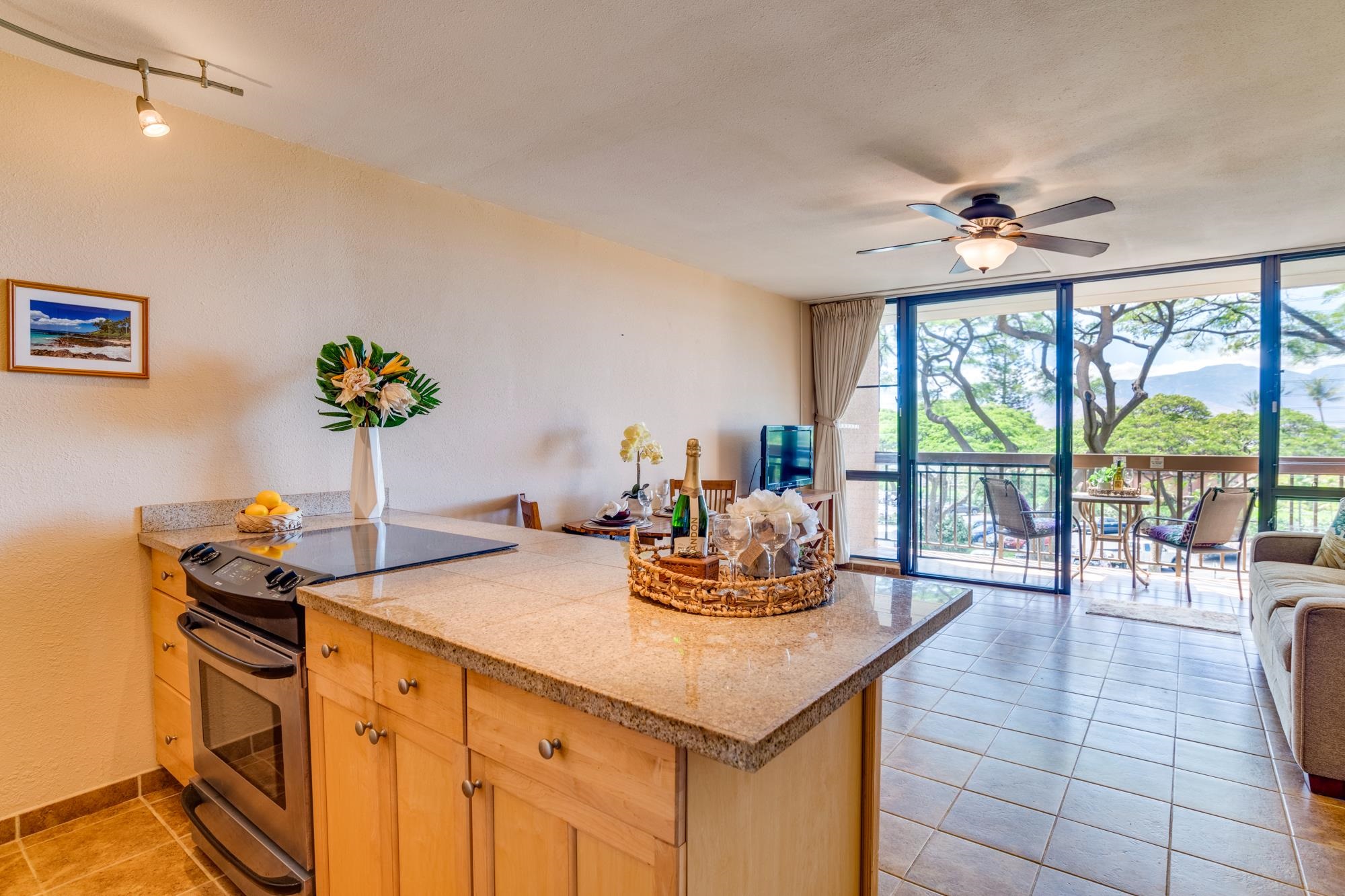 2191 South Kihei Road, Unit 2317 Kihei, HI 96753 - Photo 6 of 30 a dining room with furniture a chandelier and a flat screen tv