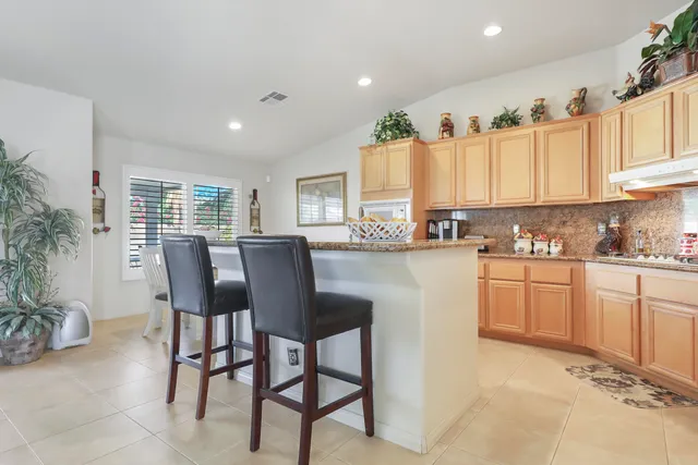 a kitchen with a table chairs sink and cabinets