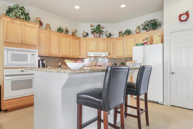 a kitchen with stainless steel appliances granite countertop a stove top oven a sink and cabinets