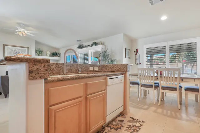 a kitchen with granite countertop cabinets and chair