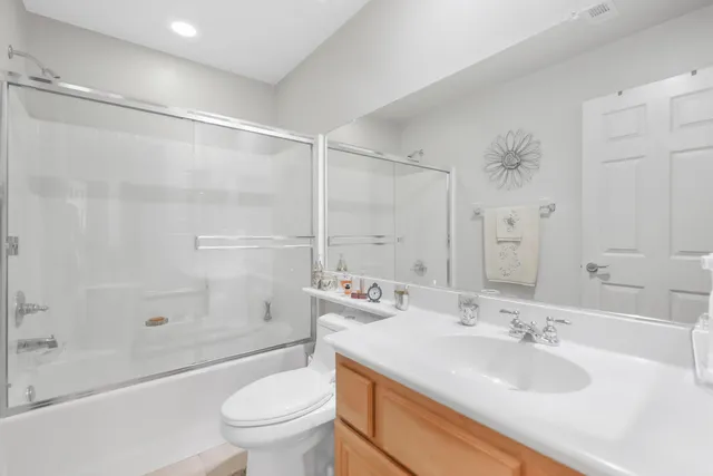 a bathroom with a sink a toilet and a large mirror